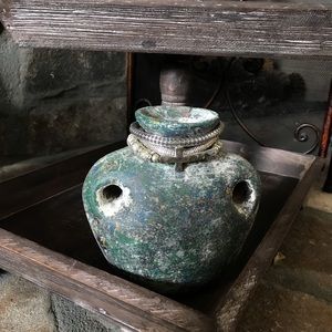 A beautiful set of silver bracelets one of which has a cross on it.